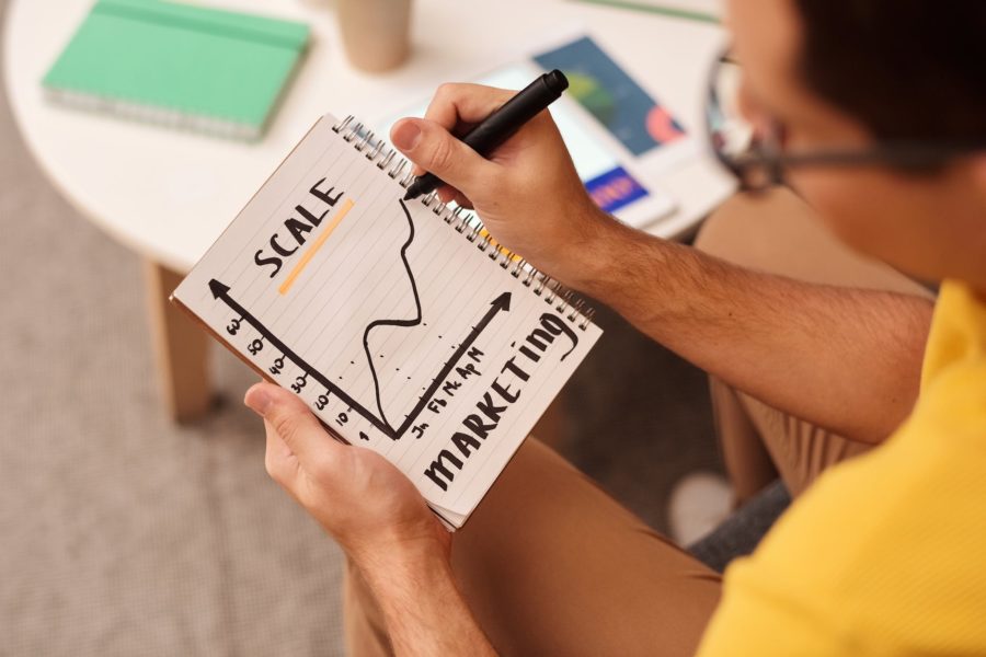 man drawing a graph on notebook